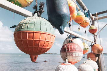 Sun faded colorful buoys for a boat hanging off a pier at tropical island Bora Bora in French Polynesia