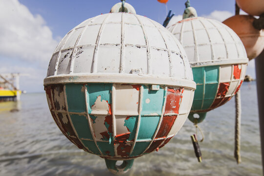Sun faded colorful buoys for a boat hanging off a pier at tropical island Bora Bora in French Polynesia