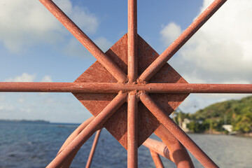Rusted metal boat lift in south pacific ocean on the tropical island Bora Bora. The steel bars make a shape within a circle including trangle. 