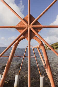Rusted metal boat lift in south pacific ocean on the tropical island Bora Bora. The steel bars make a shape within a circle including trangle. 