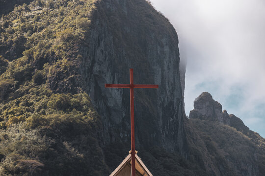 A cross sits on top of a church at the base of Mount Otemanu on the island of Bora Bora. The religious symbol represents faith.
