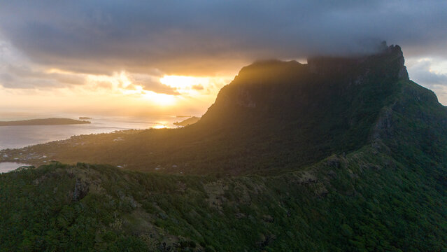 Sunset over Mount Otemanu on tropical island Bora Bora in French Polynesia. Low clouds float above the extinct volcano on the popular tourist destination in the south pacific sea. 