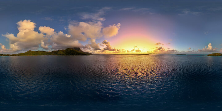 A beautiful sunrise with vibrant colors in the sky over Mount Otemanu on the tropical island of Bora Bora in French Polynesia. Panoramic view of the south pacific ocean and paradise. 