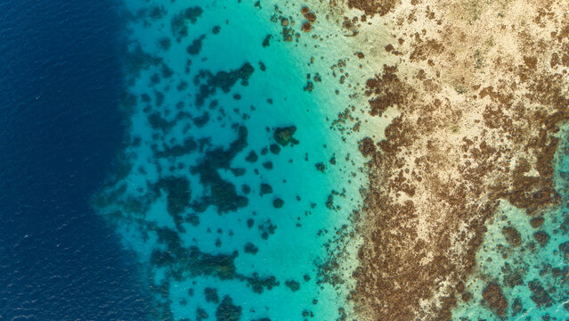 Vibrant azure blue south pacific ocean water. The clear sea reveals beautiful coral reefs at Bora Bora island in French Polynesia. 