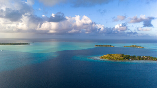 Tropical island Bora Bora in French Polynesia. The popular tourist destination in the south pacific ocean is a beautiful paradise surrounded by sea water in vibrant shades of azure, turquoise, blue. 