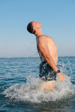 A man jumping out of the water with splashes