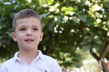 Portrait of little boy outdoors, space for text