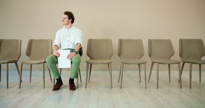 Waiting room, man and thinking with document for job interview, vacancy process and business hiring. Chairs, candidate and nervous with cv for creative agency, recruitment and designer opportunity