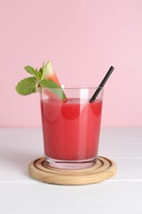 Tasty watermelon drink in glass and mint on white wooden table