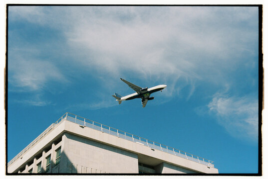Airplane in the sky flying over a building in Lisbon