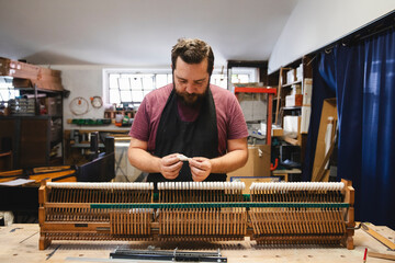 Piano Repair Craftsman Working on Piano Hammers