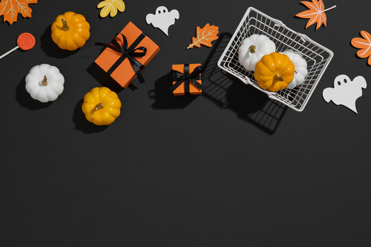 Halloween-themed pumpkins, gift box, and autumn decor on black