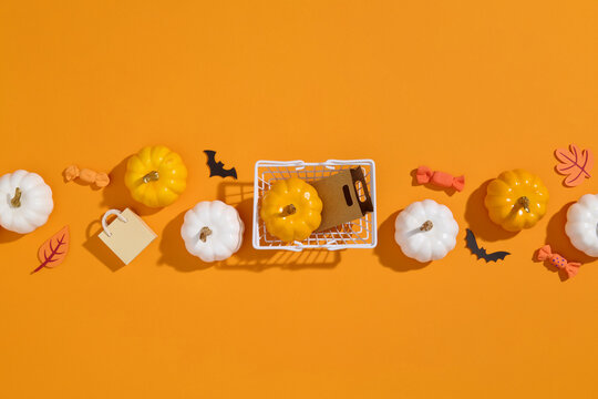 Spooky shopping cart with Halloween decorations on orange