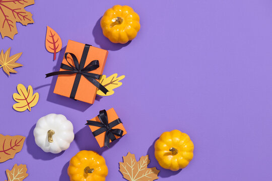 Autumnal scene with pumpkins and leaves on a purple background