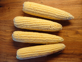 corn on the cob - 4 ears on red oak cutting board