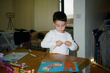 Boy Engaged in Home Craft Activity.  Film Photo With Direct Flash.