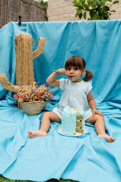 baby girl eating birthday cake