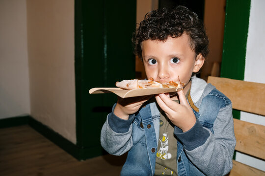Latino boy eating pizza