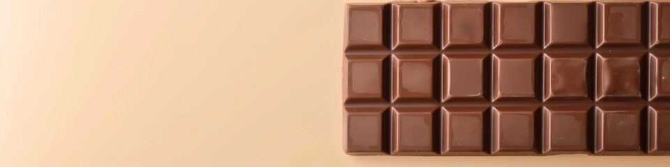 Fototapeta premium Smooth and Rich Milk Chocolate Bar on Beige Background with Copy Space - Minimalist Food