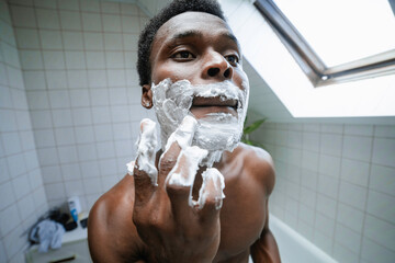 A man applies shaving foam