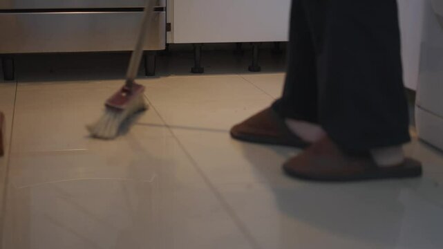 Barrer. Persona barriendo. Pasar la Escoba. Juntando la suciedad. Barriendo la cocina. Limpieza. Limpiar. Footage de Limpieza. Servicio domestico. Hogar. 