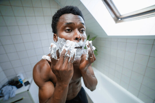 A man applies shaving foam