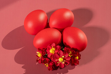Colorful eggs, symbolizing Easter, on a colorful background and flowers