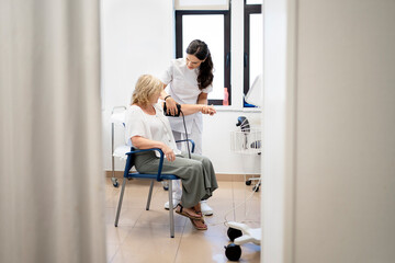 Nurse measuring blood pressure of patient in clinic