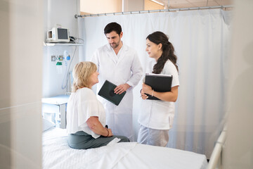 Medical team consulting with patient in hospital box room