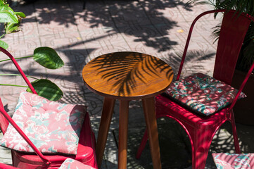 Outdoor cafe table with plant shadows on sunny day