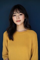 Fototapeta premium A woman in a yellow sweater is smiling at the camera
