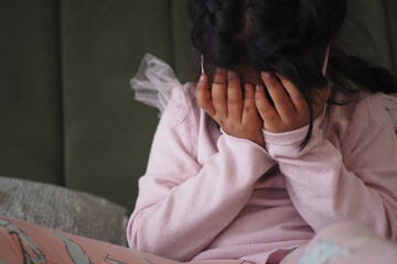A Child Covering Their Face with Hands in a Deeply Emotional Moment of Distress and Sadness