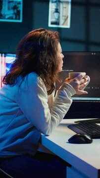 Vertical video Portrait of engineer drinking coffee in the morning and futureproofing company network from downtimes. IT admin enjoying hot beverage while increasing data security, camera B
