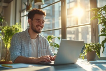 Fototapeta premium High-resolution brightly lit photorealistic candid photograph of a young marketer in casual attire, smiling as he works on his laptop in a sunlit office. The photograph is styled like a high-end