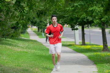 A young man is jogging with music in the city.