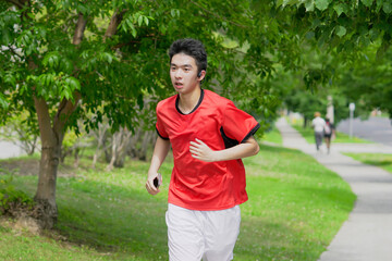 A young man is jogging with music in the city.