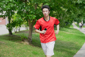 A young man is jogging with music in the city.