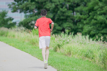 A young man is jogging with music in the city.
