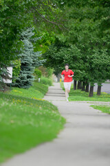 A young man is jogging with music in the city.