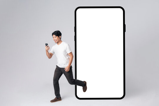 A man is running out from smartphone blank screen with empty space for mobile app on screen with happy smile on face. Concept of excitement and shopping online.