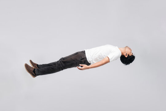 Asian man is floating in the air. Concept of freedom and weightlessness. isolated white background.