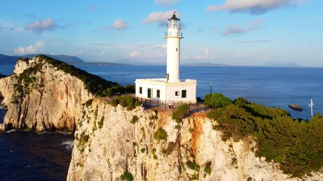 Drone shot of old lighthouse - Cape Ducato on the cliff of Lefkada island in the sunset time