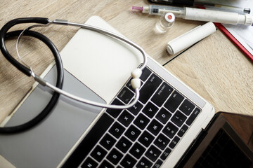 Top view of doctor's desk with laptop, stethoscope and medical equipments