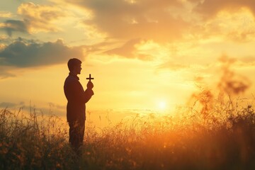 Fototapeta premium Human praying and holding christian cross for worshipping God at sunset background. 