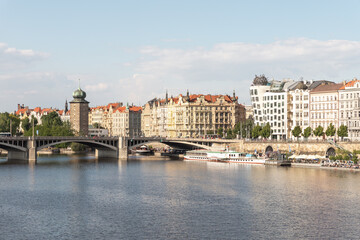 Irasekov Bridge on the Vltava River and embankment with ancient houses in Prague in Czech Republic
