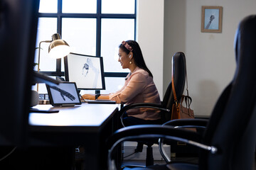 Working in office, woman using computer with robotic arm on screen