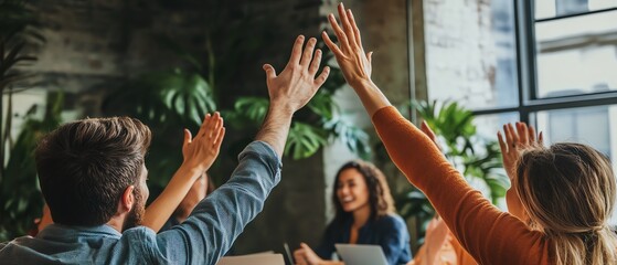 Team members enthusiastically participating in a collaborative meeting, raising hands and sharing ideas in a modern workspace.
