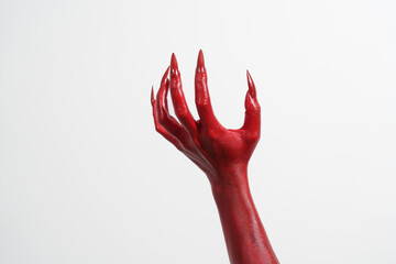 A witch's hand with long red nails on a white background, resembling a demon's or zombie's hand. This scary monster is perfect for Halloween, symbolizing a resurrected fictional creature.