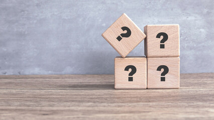 Wooden Cube with Question Mark Symbol on wooden table.