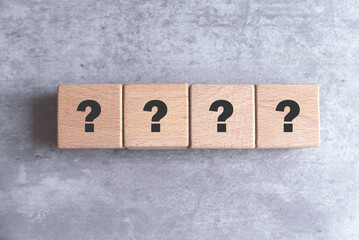 Wooden Cube with Question Mark Symbol on gray background.